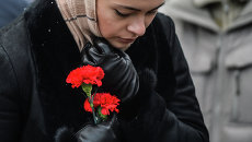 Женщина в международном аэропорту Казань несет цветы в память о погибших в авиакатастрофе самолета Boeing 737 авиакомпании Татарстан, Женщина в международном аэропорту Казань несет цветы в память о погибших в авиакатастрофе самолета Boeing 737 авиакомпании Татарстан,